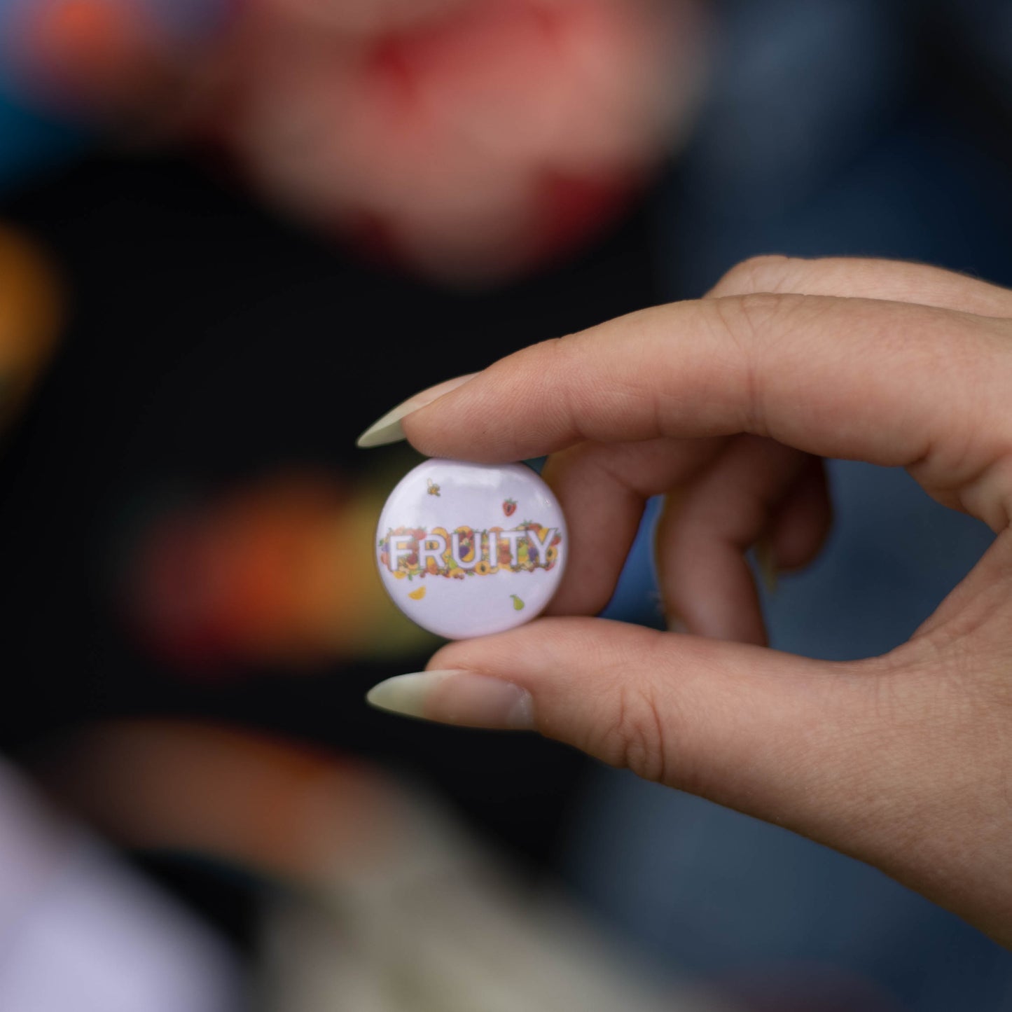 A close up picture of the "fruity" button. This button features the word FRUITY in block letters surrounded by various fruits.