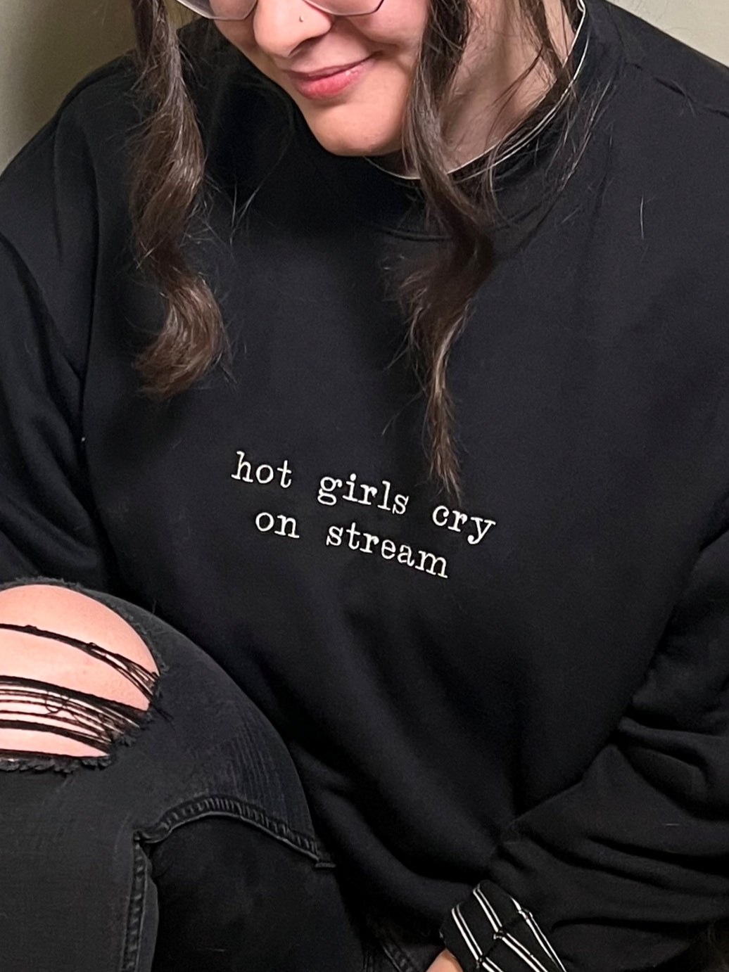 Close up picture of Ariel wearing a black crew neck with "hot girls cry on stream" embroidered on the front.