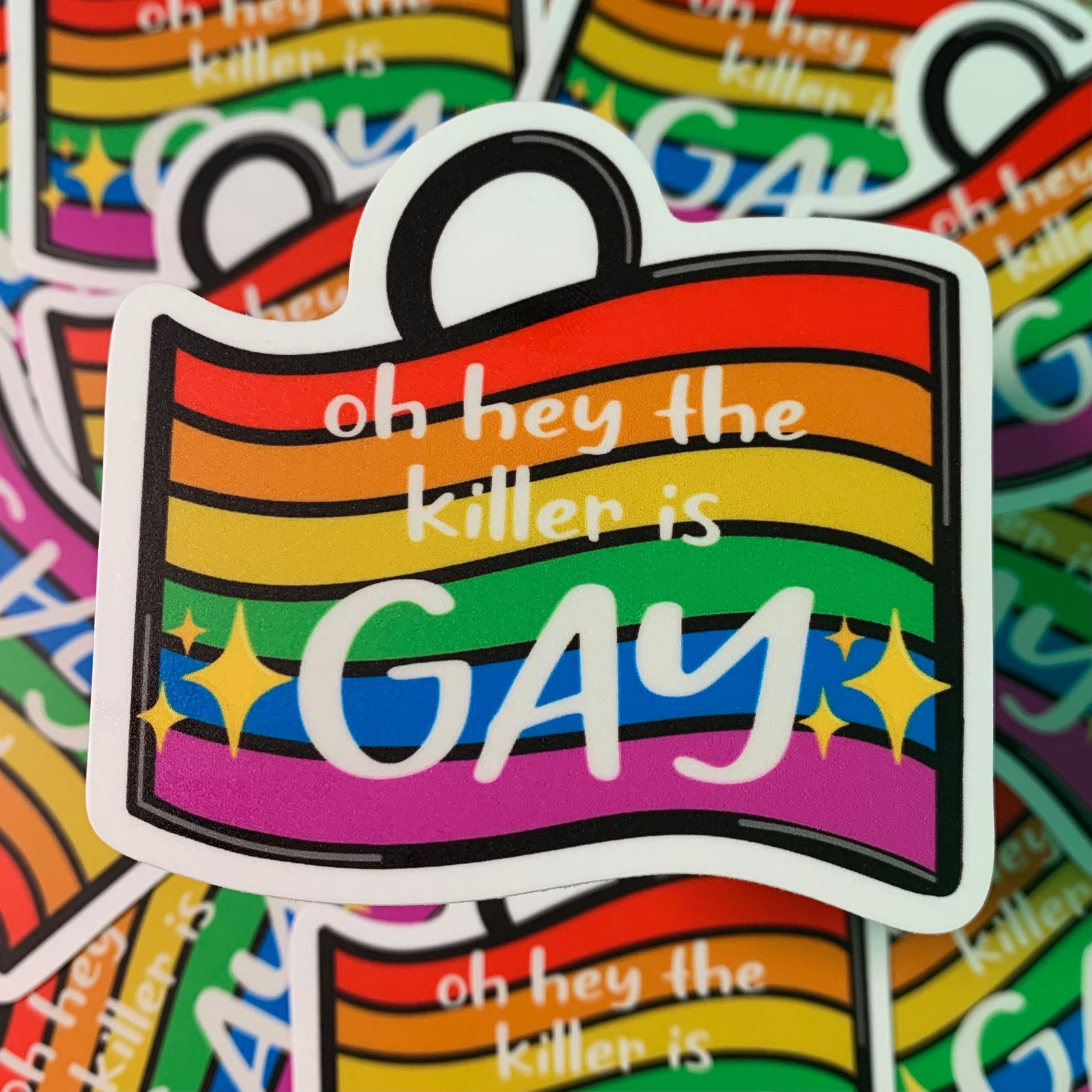 Inspired by the Pride Charm in the game Dead by Daylight, this sticker is of a rainbow flag with "oh hey the killer is GAY" written on it. The word gay has hand drawn sparkle emojis around it..